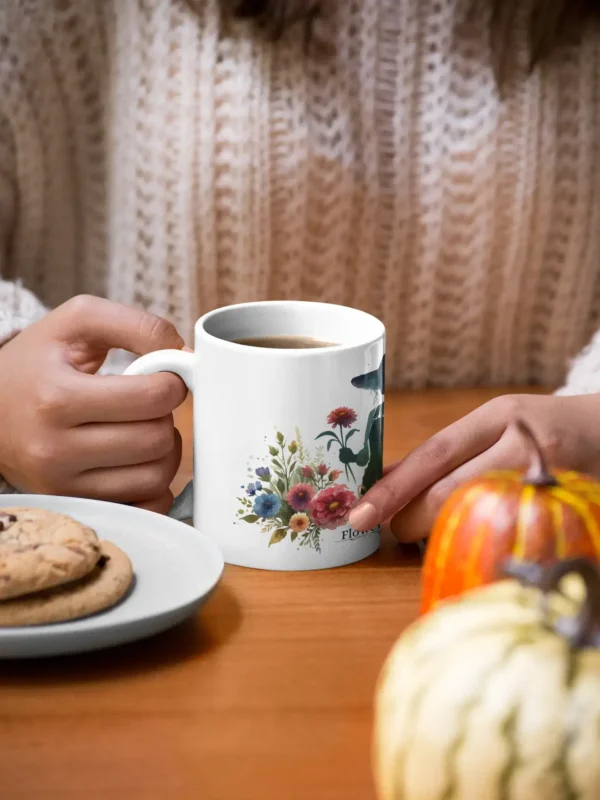 mockup of a woman holding an 11 oz mug with cookies and pumpkins at the table 29136 1 1