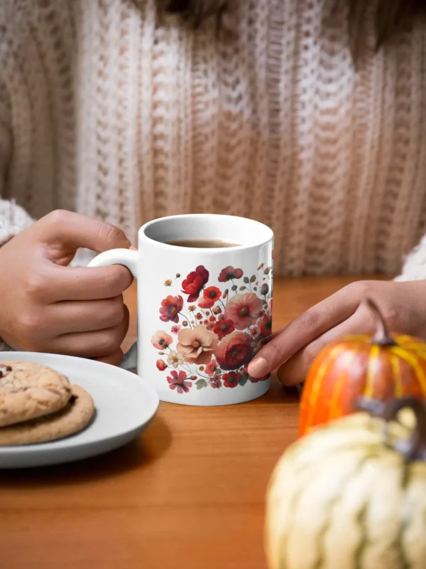 mockup of a woman holding an 11 oz mug with cookies and pumpkins at the table 29136 1 2