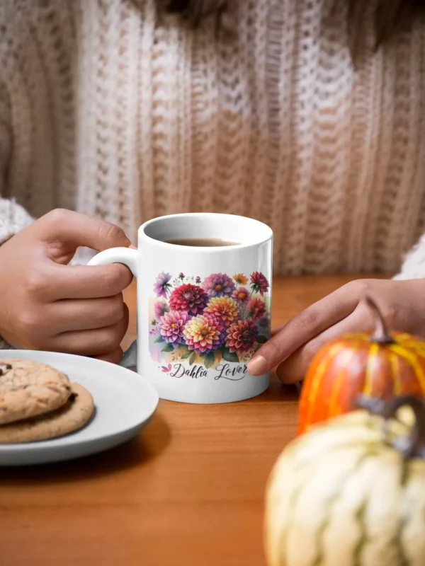 mockup of a woman holding an 11 oz mug with cookies and pumpkins at the table 29136
